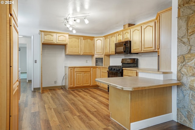 kitchen with black appliances, light hardwood / wood-style floors, kitchen peninsula, and light brown cabinetry