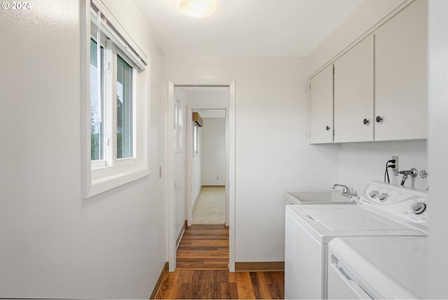 clothes washing area featuring cabinets, washer and dryer, dark wood-type flooring, and sink