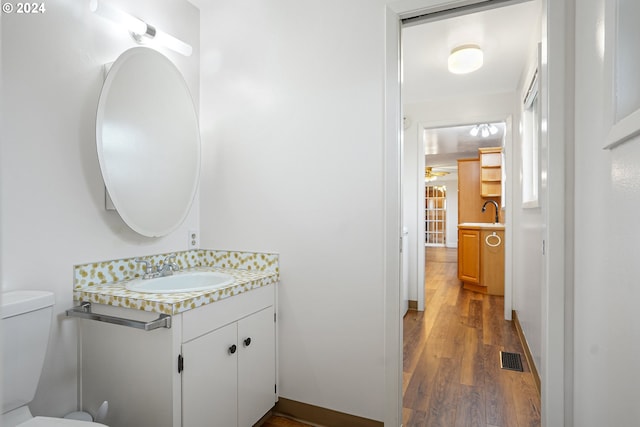 bathroom featuring toilet, vanity, and hardwood / wood-style flooring