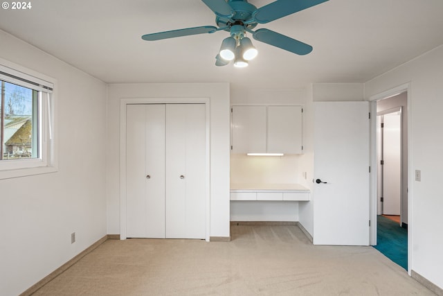 unfurnished bedroom featuring ceiling fan and light colored carpet