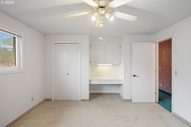 unfurnished bedroom with ceiling fan and light carpet