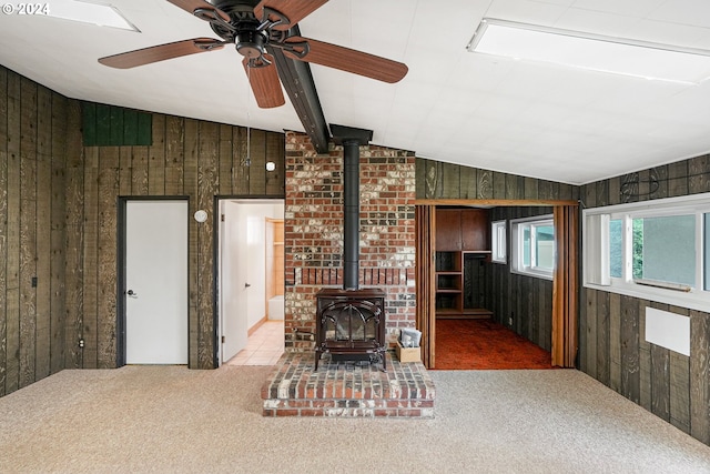 unfurnished living room with carpet, lofted ceiling, and wooden walls