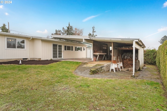 back of property with a yard and a patio