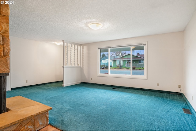 spare room featuring a textured ceiling and carpet floors