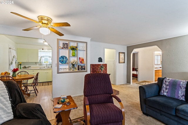 living room featuring sink, light carpet, a wealth of natural light, and ceiling fan