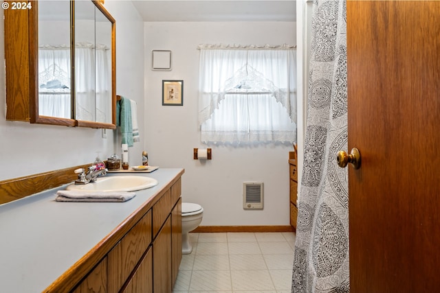 bathroom with vanity, toilet, and heating unit