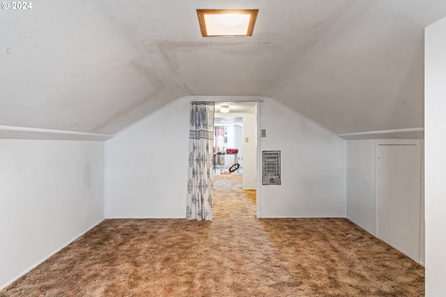 bonus room with vaulted ceiling, carpet flooring, and heating unit