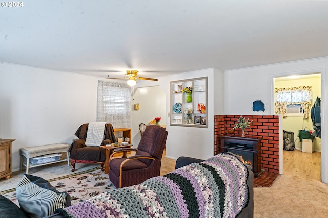 carpeted living room with ceiling fan and a brick fireplace