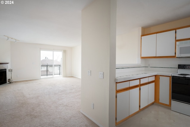 kitchen with white appliances, light carpet, and white cabinetry