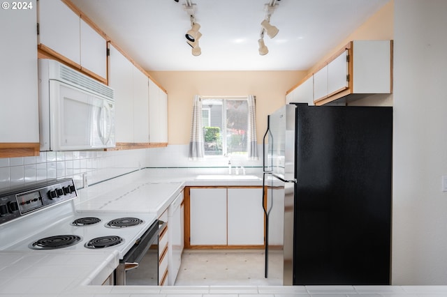 kitchen with tile counters, white appliances, track lighting, white cabinetry, and sink