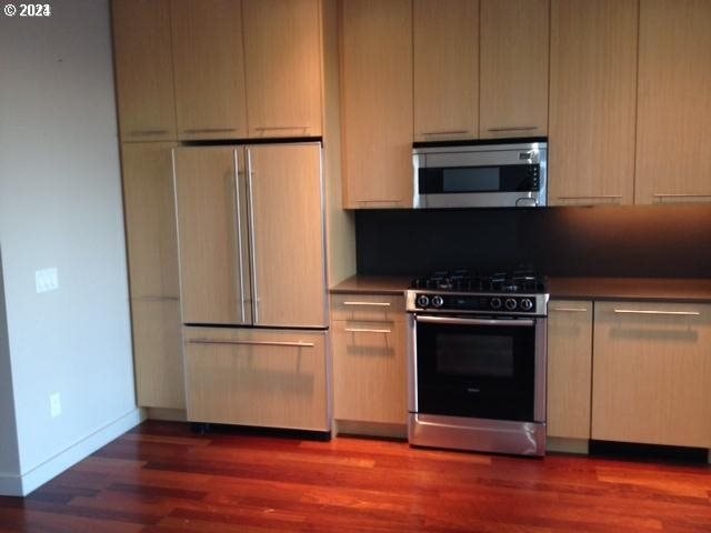 kitchen featuring dark hardwood / wood-style flooring and stainless steel appliances