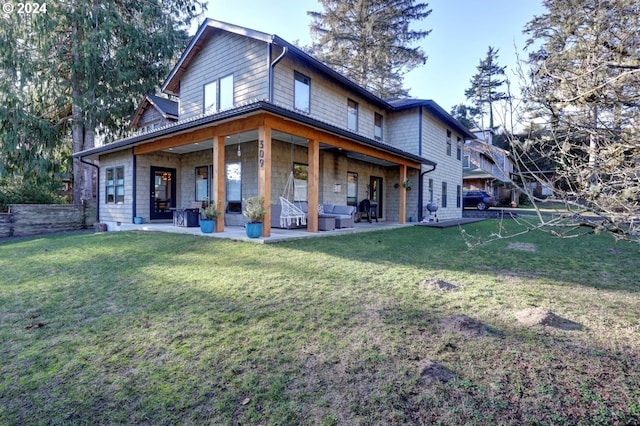 rear view of property with a yard and a patio area