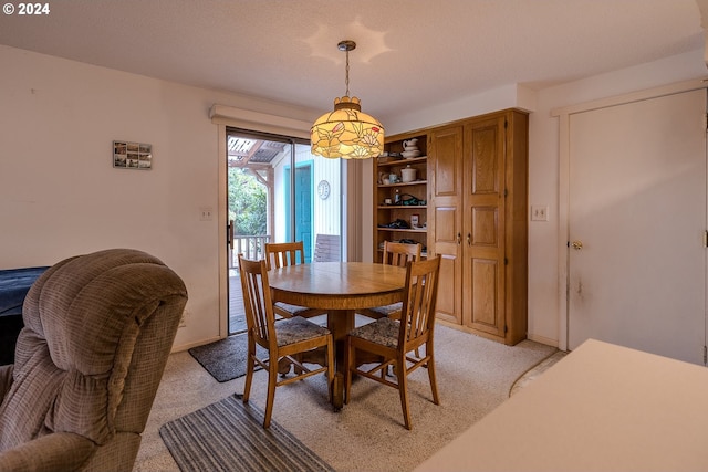 carpeted dining area featuring a textured ceiling