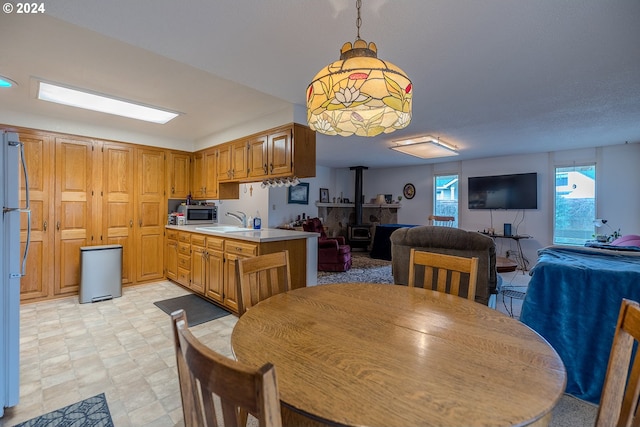 dining space with a wood stove and sink