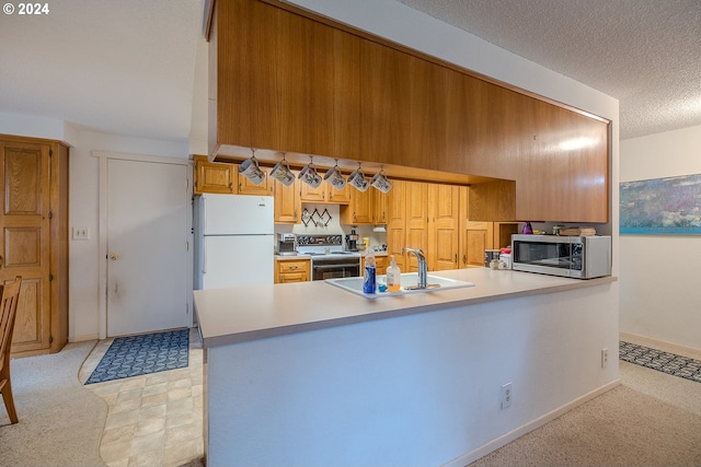 kitchen featuring kitchen peninsula, a textured ceiling, stainless steel appliances, and sink