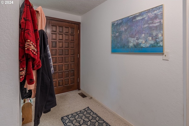 doorway to outside featuring a textured ceiling