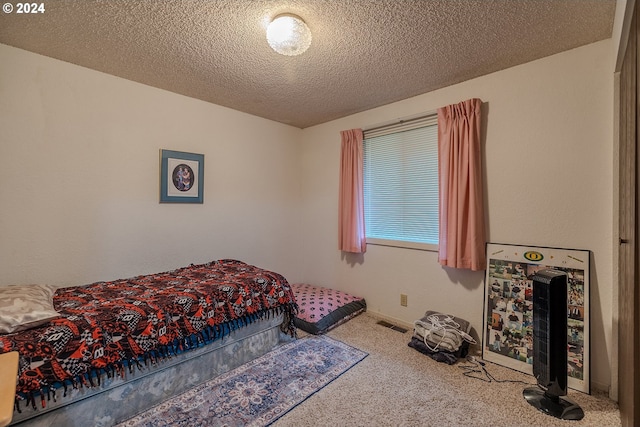 bedroom featuring carpet flooring and a textured ceiling