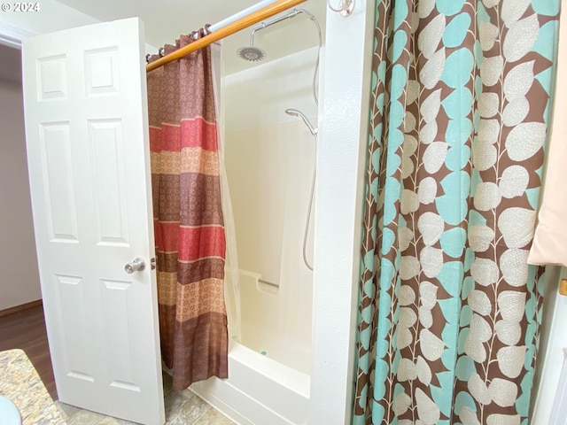 bathroom featuring wood-type flooring and shower / tub combo