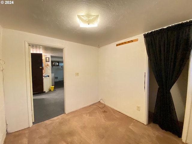 carpeted spare room with a textured ceiling