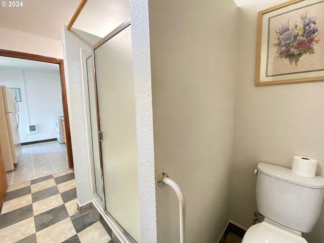 bathroom with toilet and a shower with shower door