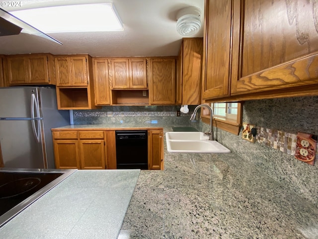 kitchen with black dishwasher, sink, tasteful backsplash, and stainless steel refrigerator