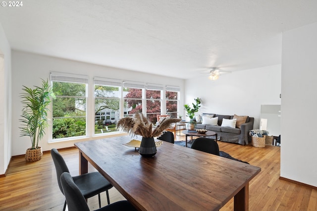 dining space featuring ceiling fan, light wood-style floors, and baseboards
