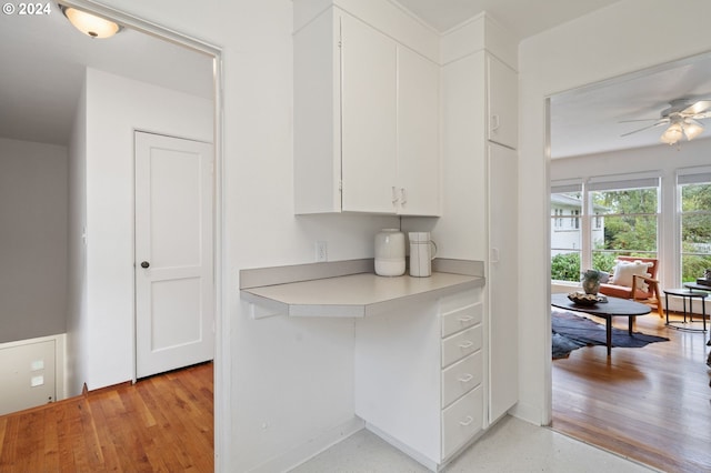 kitchen with ceiling fan, white cabinets, and light hardwood / wood-style flooring