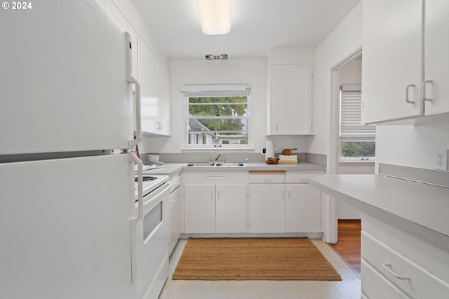 kitchen with white cabinets, sink, and white appliances