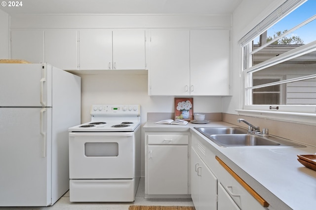 kitchen featuring white appliances, white cabinetry, and sink