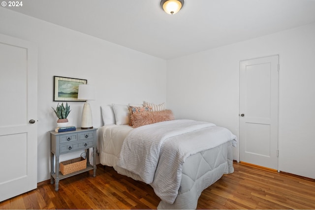 bedroom with dark wood-type flooring