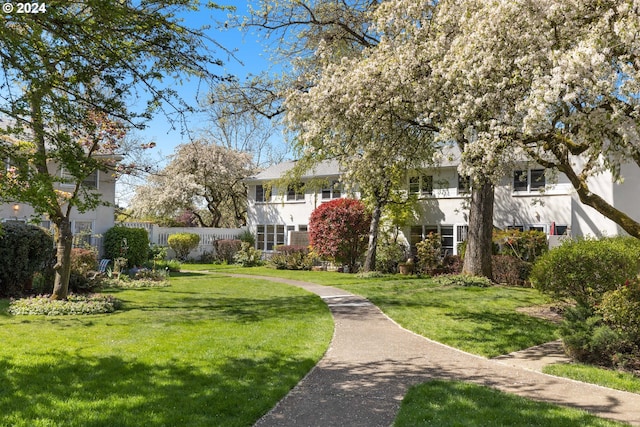 view of community featuring fence and a lawn