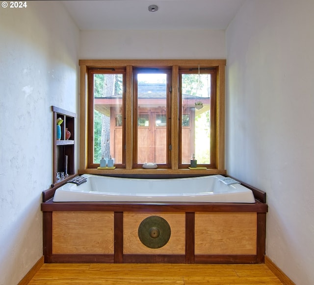 2275 Floral Hill Dr, Eugene, OR 97403 - bathroom featuring a washtub and hardwood / wood-style flooring