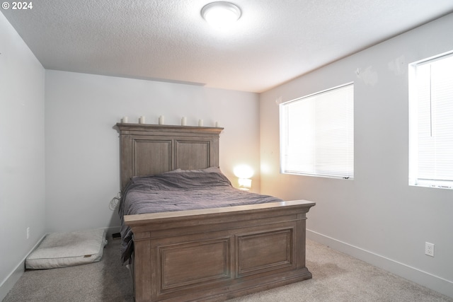 carpeted bedroom featuring a textured ceiling