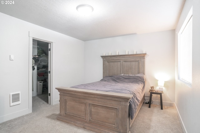 bedroom with a closet and light carpet