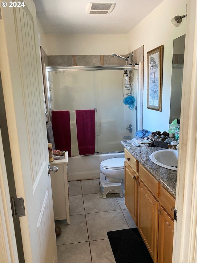 full bathroom featuring vanity, toilet, tiled shower / bath combo, and tile patterned floors