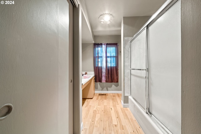 bathroom with a shower with door, vanity, and hardwood / wood-style flooring