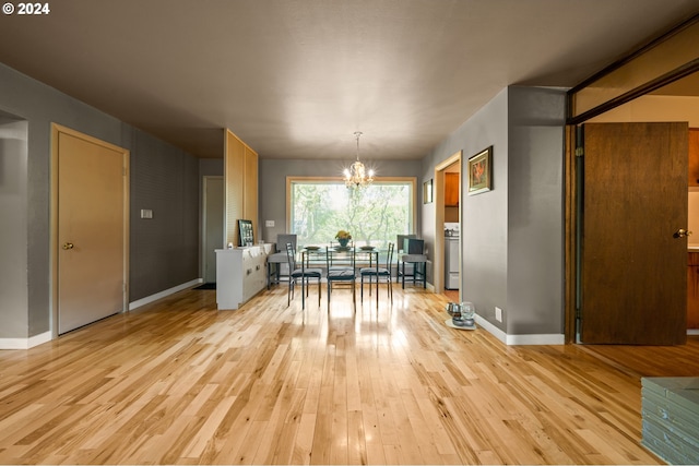 dining room with light hardwood / wood-style flooring and an inviting chandelier