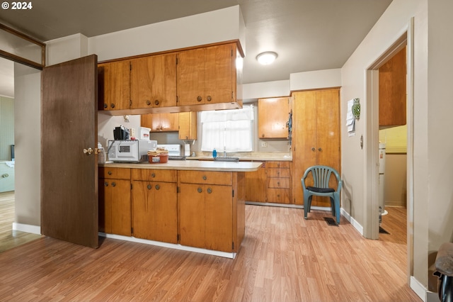 kitchen with kitchen peninsula and light hardwood / wood-style floors