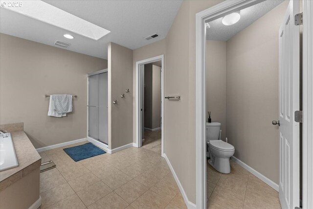 5898 SE Thornapple St, Hillsboro, OR 97123 - bathroom with a skylight, toilet, a shower stall, baseboards, and vanity