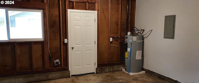 utility room with strapped water heater and electric panel