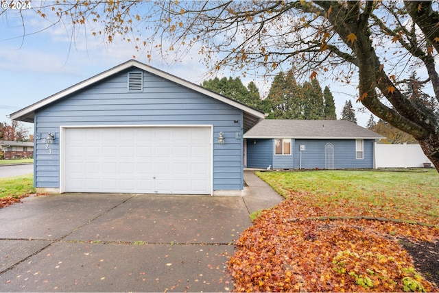 ranch-style home with a garage and a front lawn