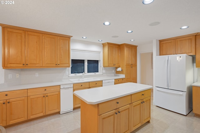 kitchen with white appliances, a center island, and sink