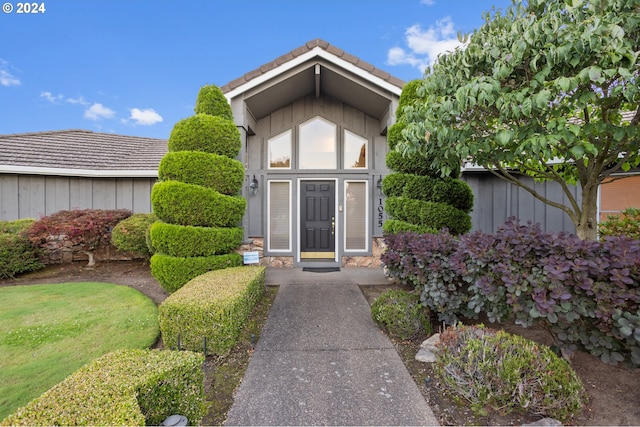 view of exterior entry with a lawn