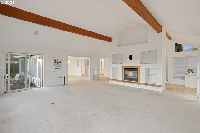 unfurnished living room featuring high vaulted ceiling, beamed ceiling, and a healthy amount of sunlight