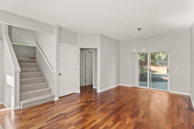 unfurnished living room featuring dark hardwood / wood-style floors and an inviting chandelier