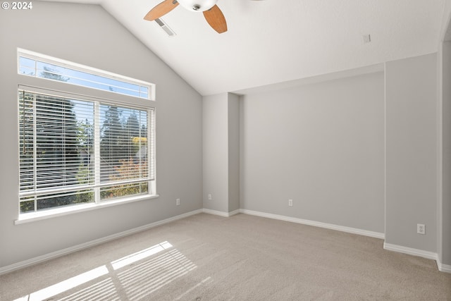 carpeted empty room featuring a healthy amount of sunlight, lofted ceiling, and ceiling fan