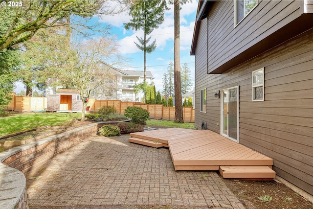 view of patio featuring a storage unit and a wooden deck