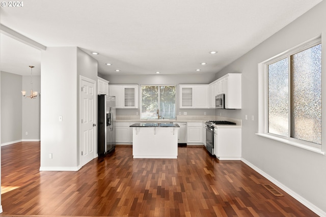 kitchen featuring a wealth of natural light, appliances with stainless steel finishes, a center island, and white cabinets