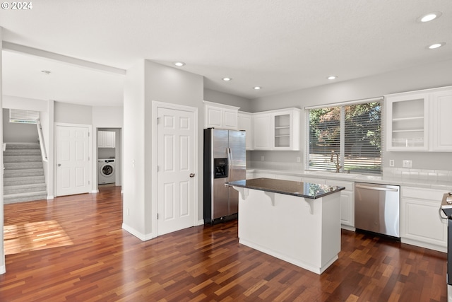 kitchen featuring white cabinets, stainless steel appliances, a breakfast bar, and a center island