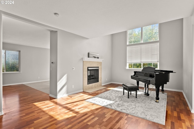 living area featuring a tile fireplace and hardwood / wood-style flooring